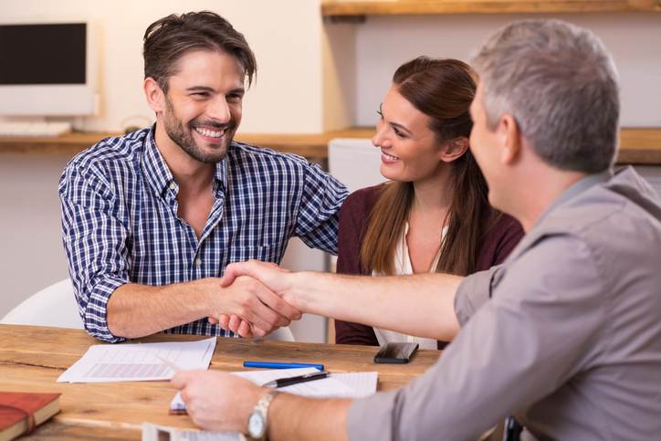 Couple shaking hand to financial agent